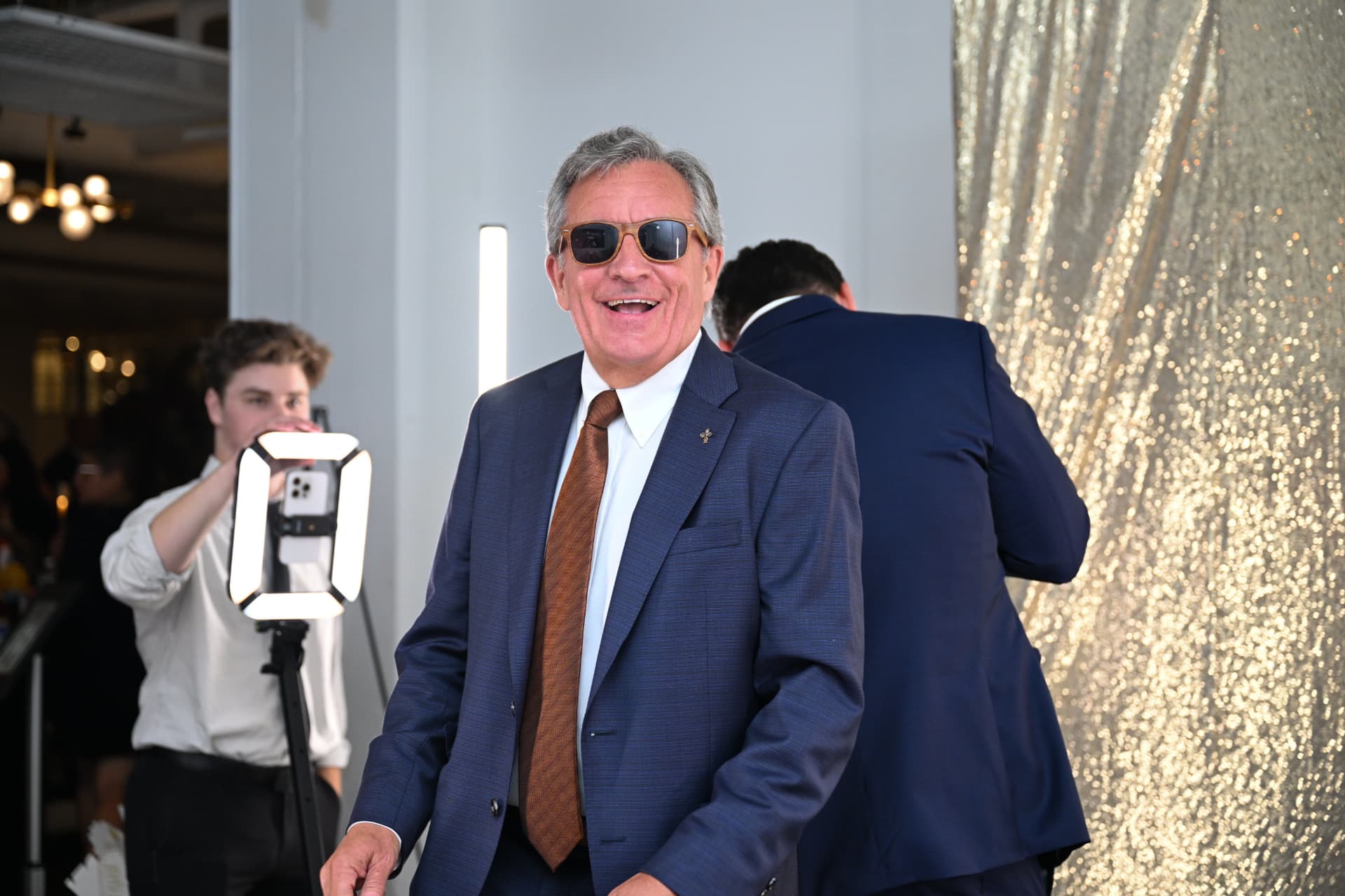 Guest in a navy suit smiling at the Fueling Hope Gala