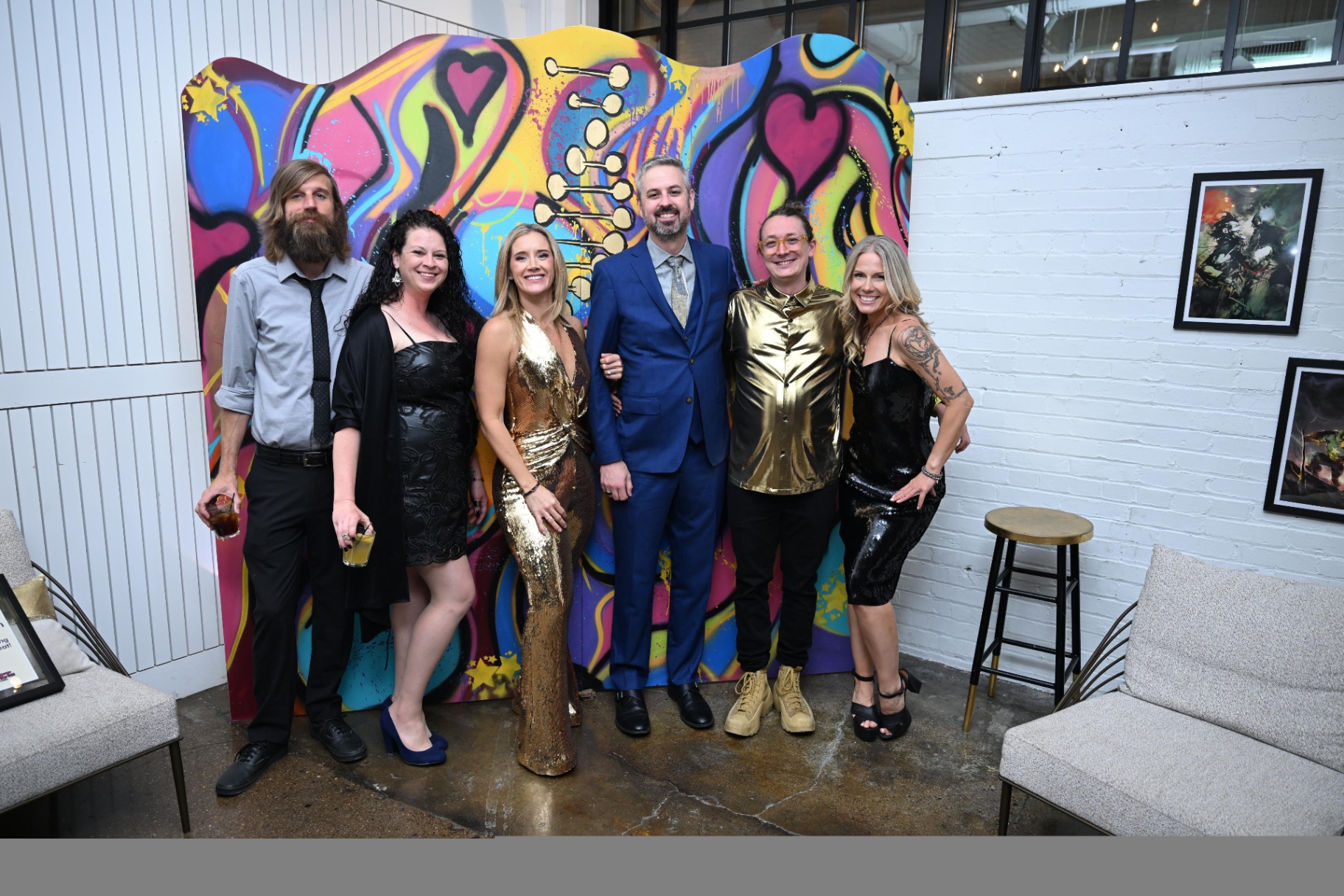 Group of guests posing in front of the colorful gala backdrop